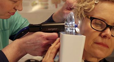 Dr. Joy Hooter performing Earigator ear wax removal on a patient at Hooter Hearing in Waco TX
